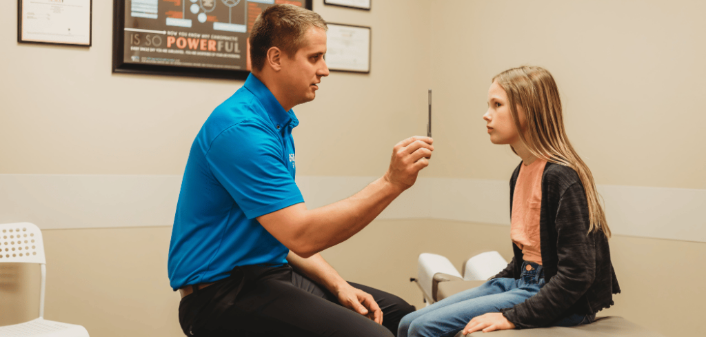 Chiropractor checking young girl's eyes